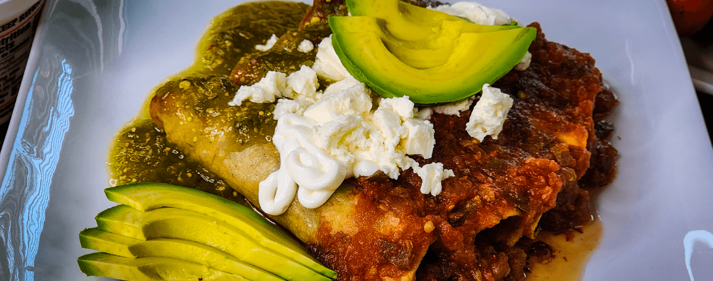 Mexican flautas stuffed with meat, topped with Mama Lycha Mexican Style Sour Cream, avocado, cheese and sauces