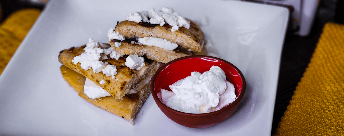 Corn Riguas stuffed with fresh cheese, served with Venezuelan Style Sour Cream